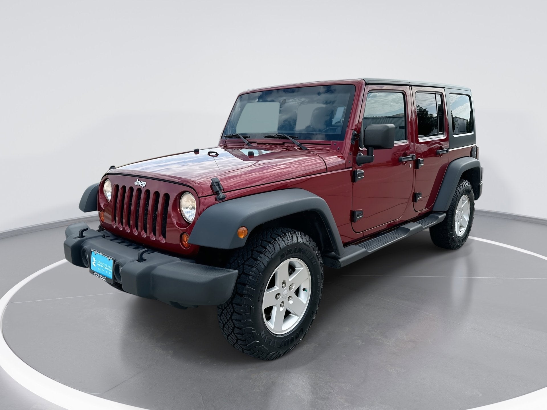 2012 Jeep Wrangler Unlimited Sport in Deep Cherry Red — front three-quarter view